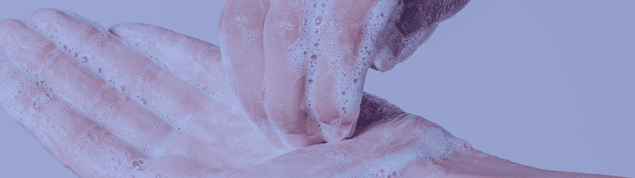 Pessoa lavando as mãos com água e sabão